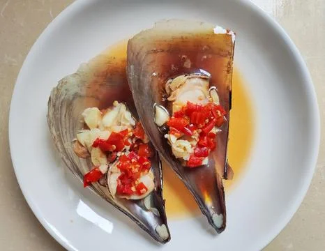 The fresh shellfish cooked with red pepper in the plate Stock Photos