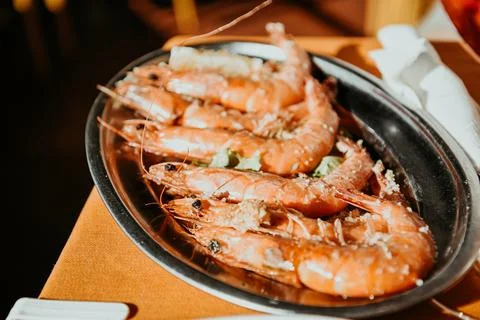 Fresh shrimps not peeled, on an aluminum plate with salt and lemon in a res.. Stock Photos
