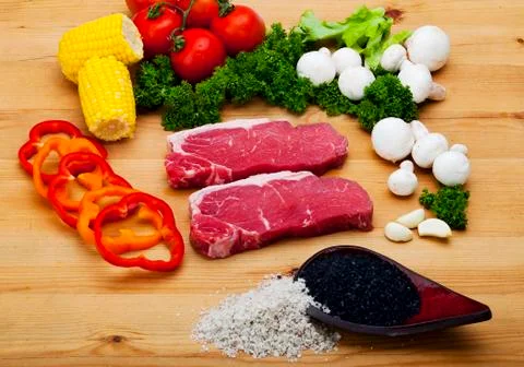 Fresh silver side tip steak with vegetables and spices on wood background. food 写真素材