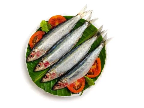 Fresh Slender Rainbow Sardine decorated with vegetables and herbs on a wooden Stock Photos