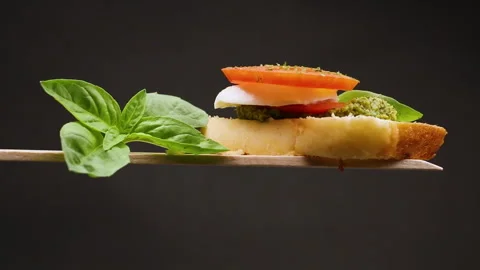 Fresh slice of bread with pesto sauce, mozzarella and tomato Stock Footage 255804710