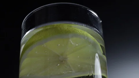 Fresh slice of lemon floating in a glass of cold water. Stock Footage 101631873