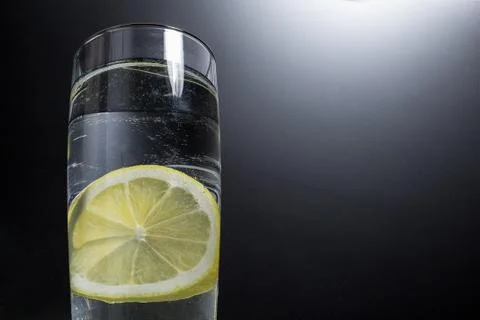 Fresh slice of lemon in a glass of cold water. Stock Photos