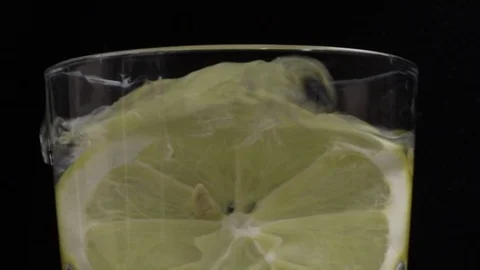 Fresh slice of lemon thrown into a glass of cold water. Stock Footage 101631871