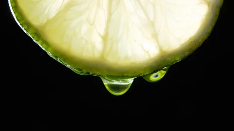 Fresh slice lime, a drop of water falls. Black background Video stock 101476911