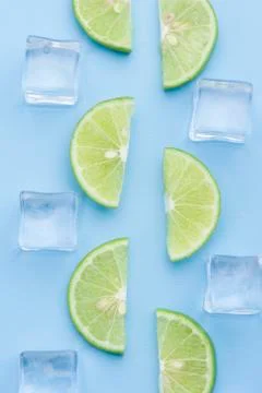 Fresh slice lime with ice cube on blue Stock Photos