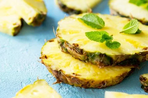 Fresh slice pineapple on stone background or slate with copy space. Stock Photos