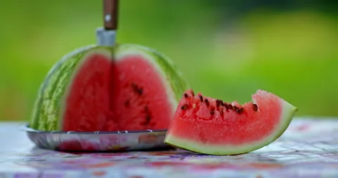 Fresh slice of watermelon on table in village house in garden, closeup view, 4K Stock Footage 229428571