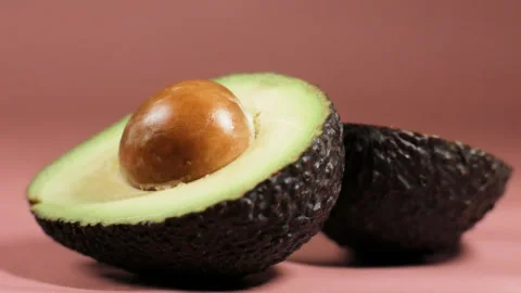 Fresh sliced avocado on pink background close-up. Stock Footage 262748836
