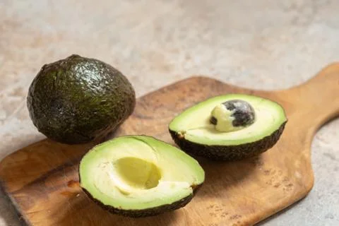 Fresh sliced avocado on wooden table Stock Photos