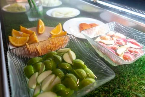 Fresh sliced fruit on a buffet table. Asian buffet restaurant. Stock Photos