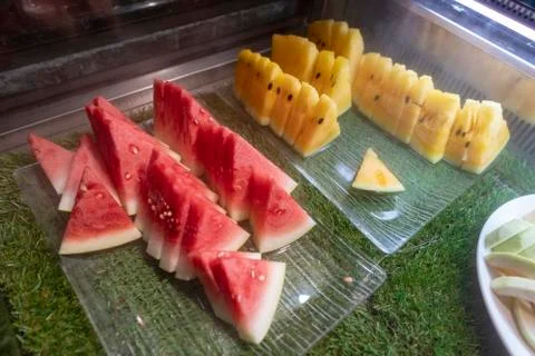 Fresh sliced fruit on a buffet table. Asian buffet restaurant. Stock Photos