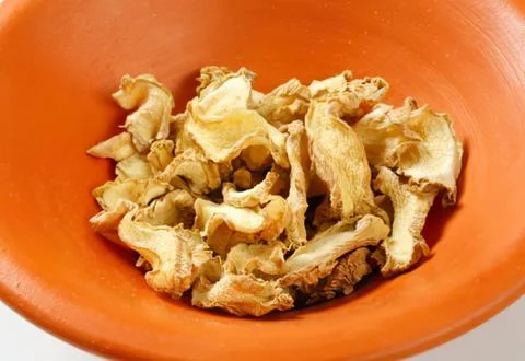 Fresh sliced ginger root in orange bowl Foto stock
