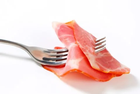 Fresh sliced ham on fork close up Stock Photos