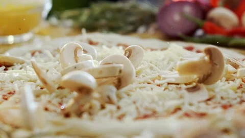 Fresh sliced mushrooms falling on raw pizza dough with grated cheese in slo.. Stock Footage 337599414