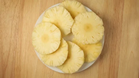 Fresh sliced pineapple rotating on a plate Stock Footage 344915526