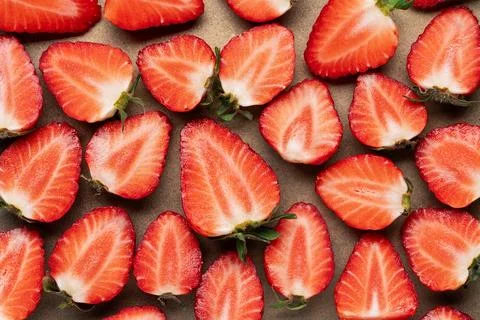 Fresh sliced strawberries pattern on beige background Stock Photos