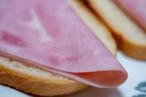 Fresh slices of cooked ham on white bread for breakfast or snack Stock Photos