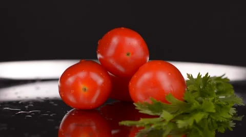 Fresh small tomatoes metallic plate and black background Stock Footage 65227812