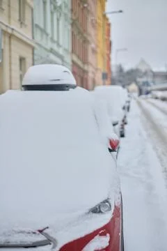 Fresh snow and removing snow cover from red parked car outdoor Stock Photos