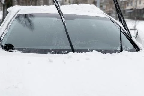 Fresh snow ice layer on windscreen,windshield,hood of car. cleaning snow afte Stock Photos