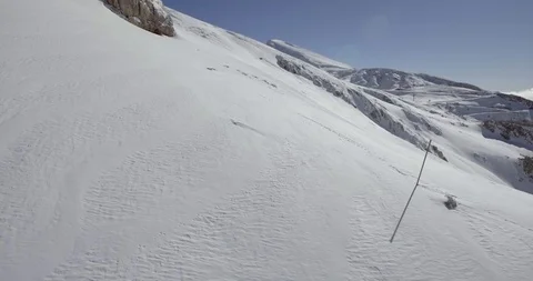 Fresh snow slope through rocks with ski resort Stock Footage 104654957