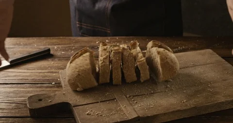 A fresh soft sliced bread baker throws on a chopping wooden board Stock Footage 88796302