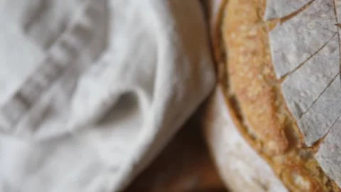 Fresh sourdough bread on kitchen table birdseye view pan right Stock Footage 196000134