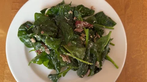 Fresh spinach salad with tuna, sun-dried tomatoes and cheese on white plate Stock Footage 345327482