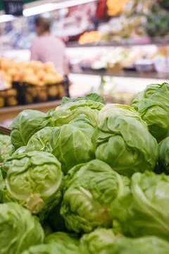 Fresh spring cabbage on counter, vegetable department in grocery store, mall Stock Photos