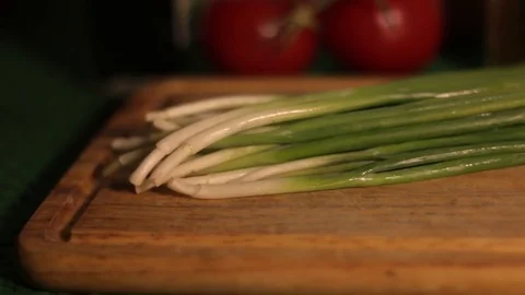 Fresh spring onions in a row on old wooden table Stock Footage 80991270