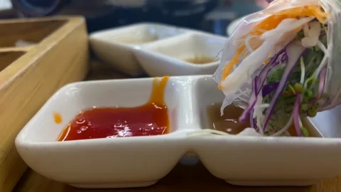 Fresh spring roll dipped in savory soy sauce enhances its rich umami flavor. The Stock Footage 301517359