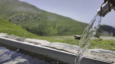 Fresh spring water flowing into a mountain trough Stock Footage 338066345
