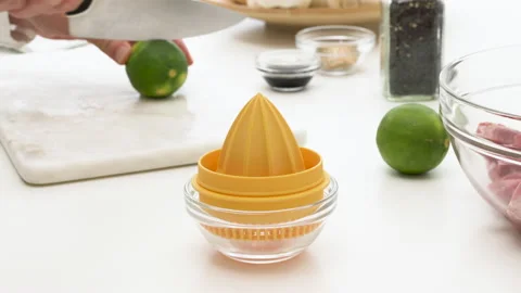 Fresh-squeezed lemon juice. Chef squeezing lemon with a mechanical citrus juicer Stock-Footage 131757576