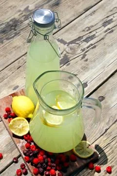 Fresh squeezed lemonade in pitchers with raspberry fruit Stock Photos