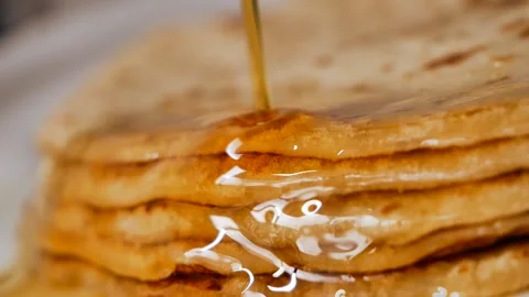 Fresh stacked pancakes is doused with maple syrup - sweet delicious breakfast Stock Footage 153670816