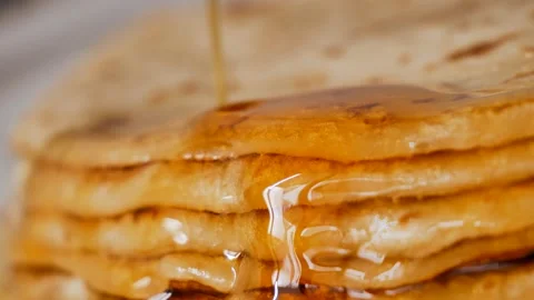 Fresh stacked pancakes is doused with maple syrup - sweet delicious breakfast Stock Footage 153671145