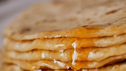 Fresh stacked pancakes is doused with maple syrup - sweet delicious breakfast Stock Footage 153671200
