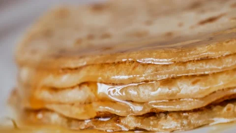 Fresh stacked pancakes is doused with maple syrup - sweet delicious breakfast Stock Footage 153672603