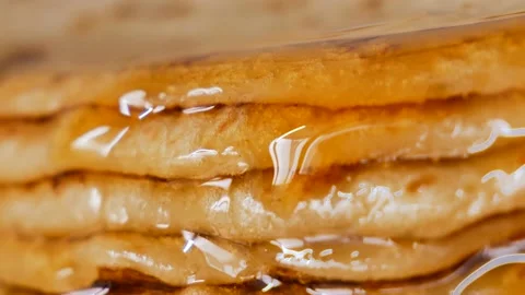 Fresh stacked pancakes is doused with maple syrup - sweet delicious breakfast Stock Footage 153673252