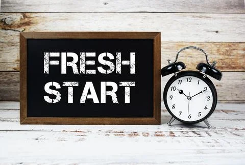 Fresh Start text message and alarm clock on wooden background Foto stock