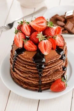 Fresh strawberries and chocolate topping on a pile of pancakes Stock Photos