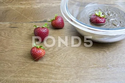 Fresh strawberries and glass bowl of chocolate Stock Photos