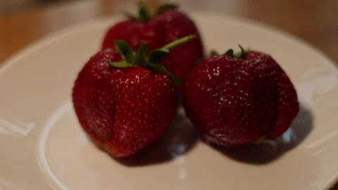 Fresh strawberries - hand picking ripe berries from white plate Video stock 338192240