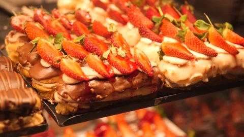 Fresh strawberries on pastries in bakery display Stock Footage 315260918