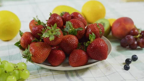 Fresh strawberries stacked on one another on plate near other fruit in kitchen Stock Footage 341220366