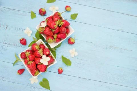 Fresh strawberry  in white bowls on  blue wooden board Stock Photos