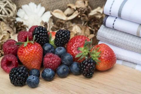 Fresh summer berries in rustic kitchen setting Stock Photos