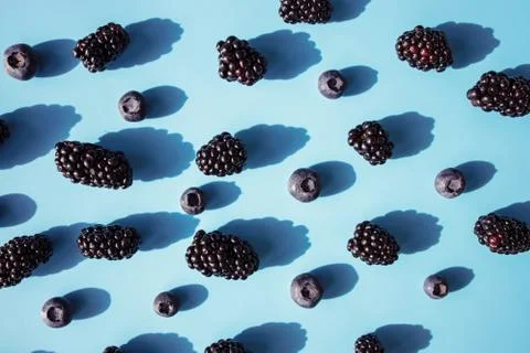 Fresh summer pattern with berries on blue table Stock Photos