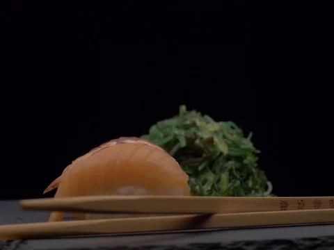 Fresh sushi on black table in motion Stock Footage 84942574